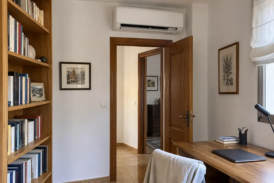 Aire acondicionado para una estancia Split de aire acondicionado sobre la puerta de una habitación con escritorio