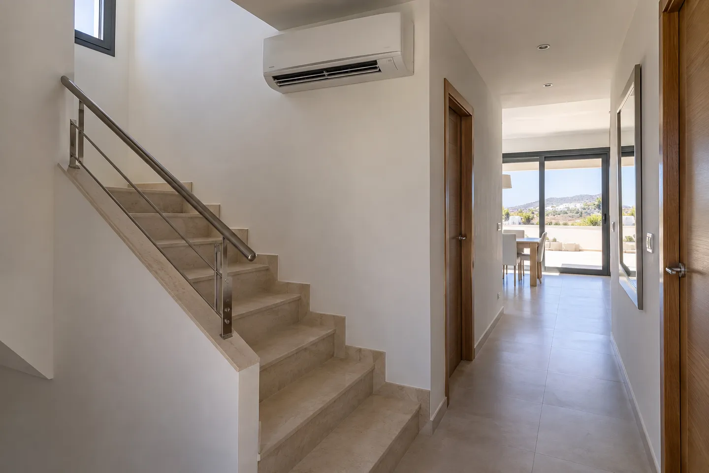 Aire acondicionado junto a una escalera interior de una casa de dos plantas
